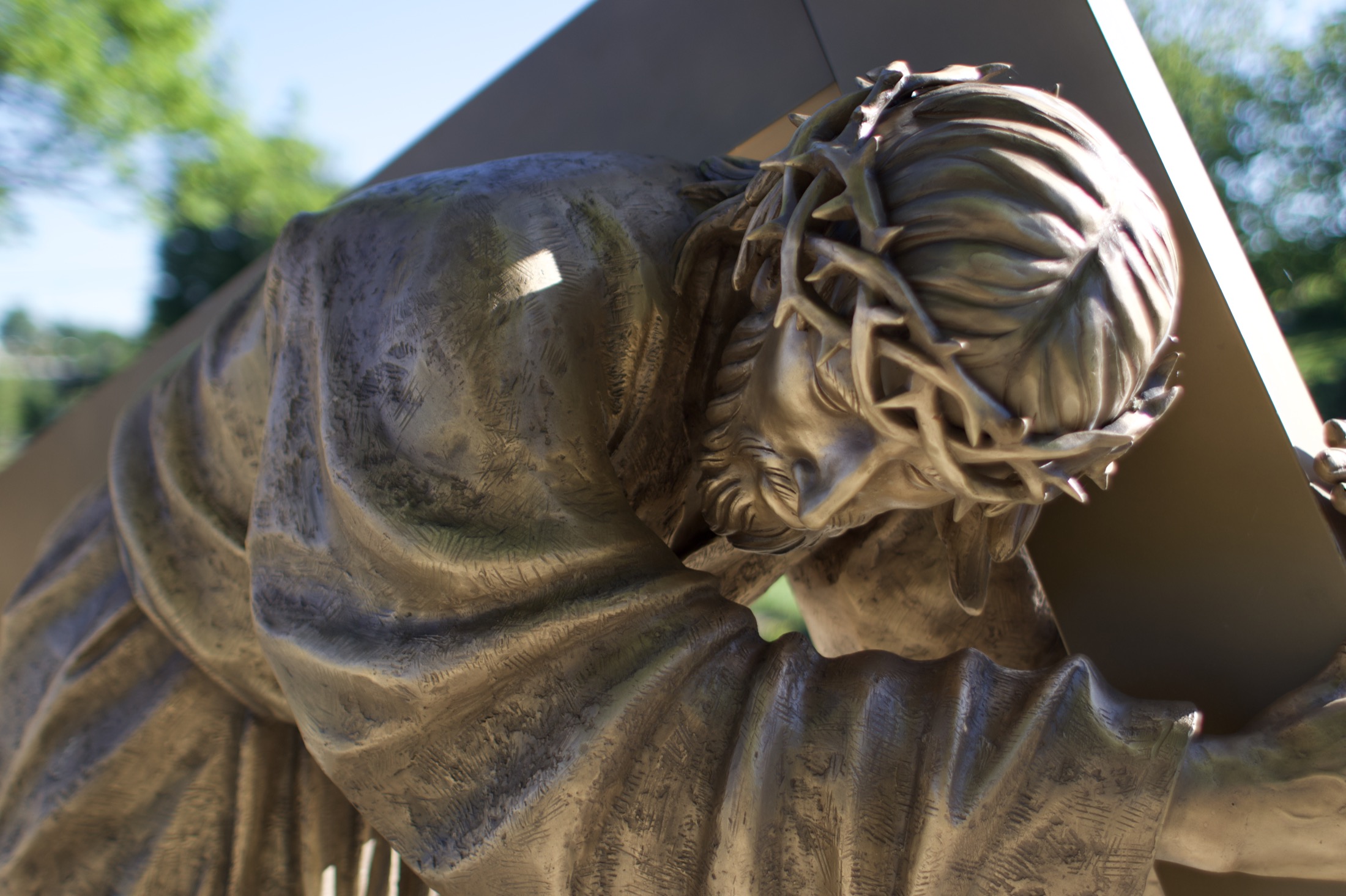 A close detail of the crown of thorns on a bronze figure of Christ carrying the cross.
